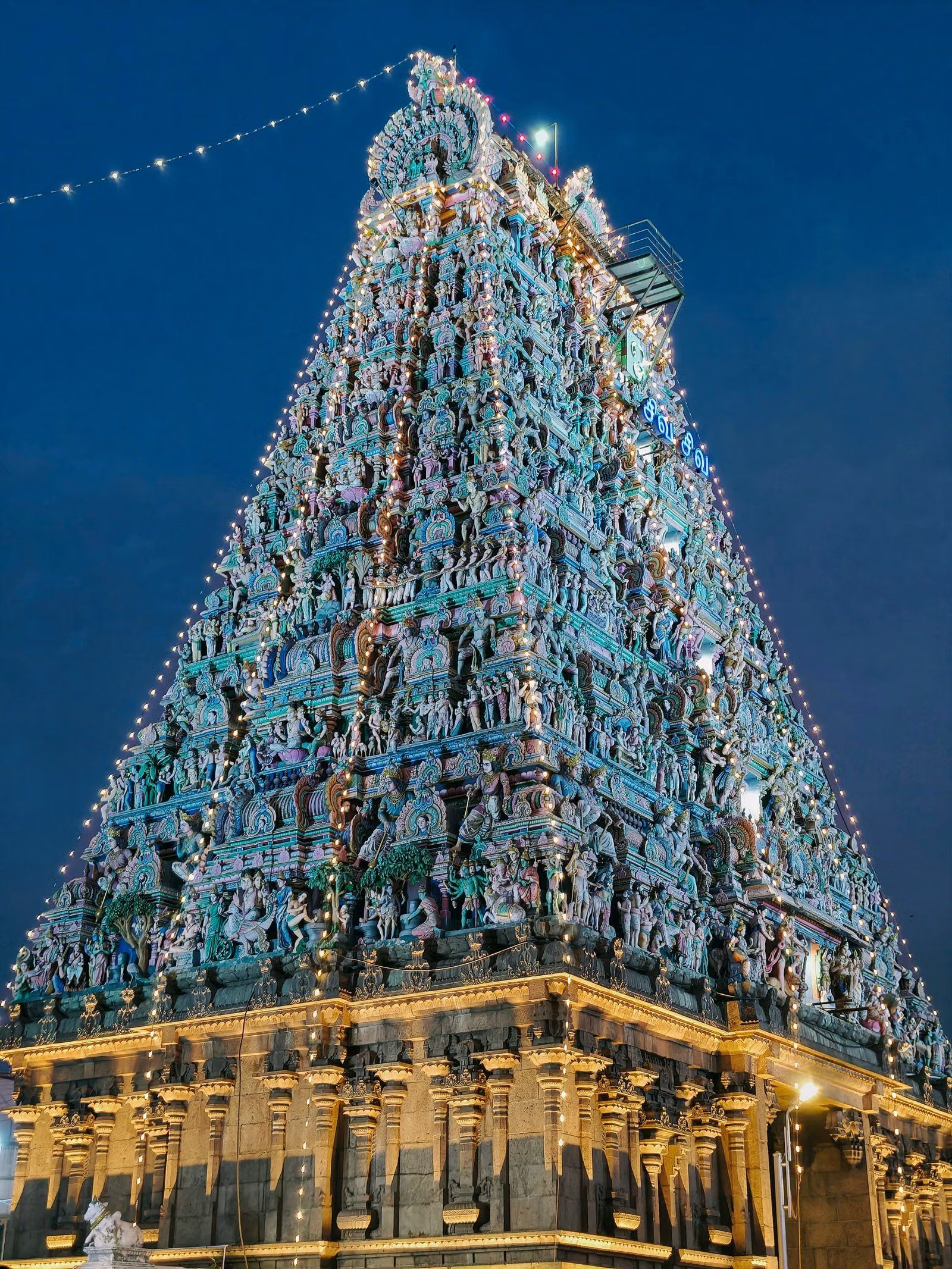 Illuminated South Indian temple gopuram at night — the source of our raw temple hair